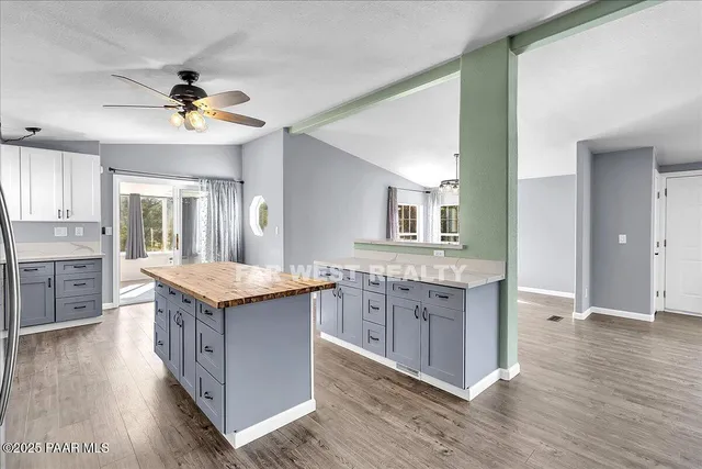a kitchen with granite countertop a stove refrigerator and cabinets