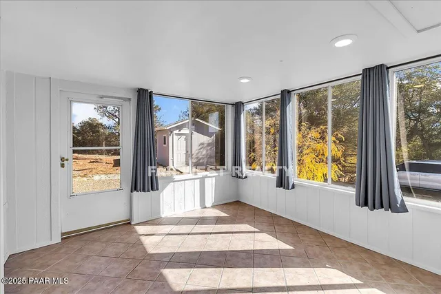 a view of an entryway with wooden floor and garden