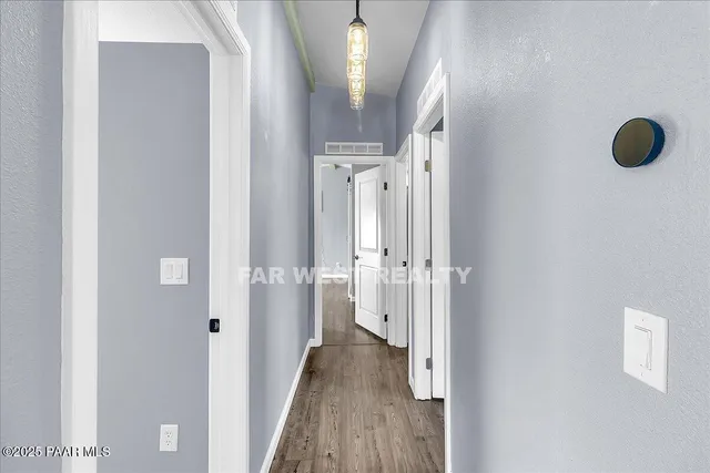 a view of a hallway with wooden floor