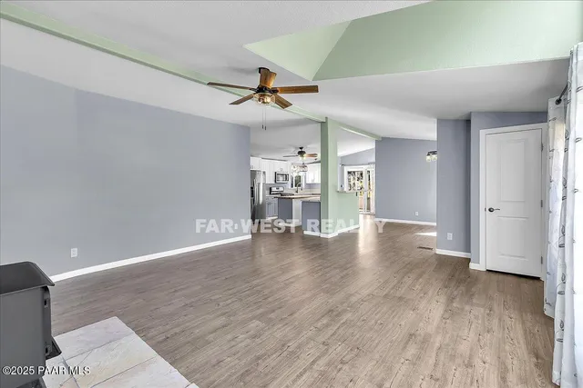 a view of a livingroom with wooden floor and a ceiling fan