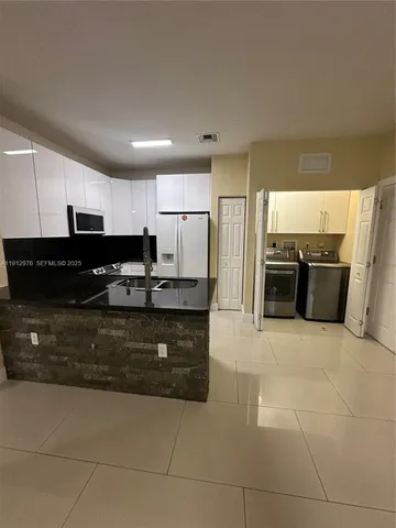 a kitchen with stainless steel appliances granite countertop a refrigerator and a stove top oven