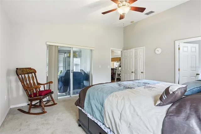 a spacious bedroom with a bed chairs and a chandelier