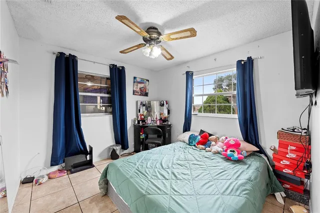 a bed room with a bed tv and a window