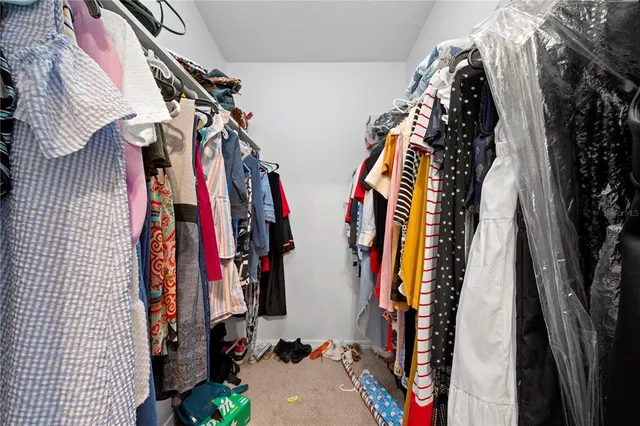 a view of walk in closet with clothes