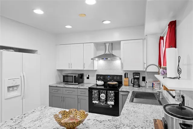a kitchen with stainless steel appliances granite countertop a stove a sink and a refrigerator