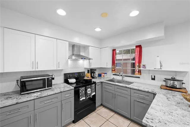a kitchen with granite countertop a sink stainless steel appliances and cabinets