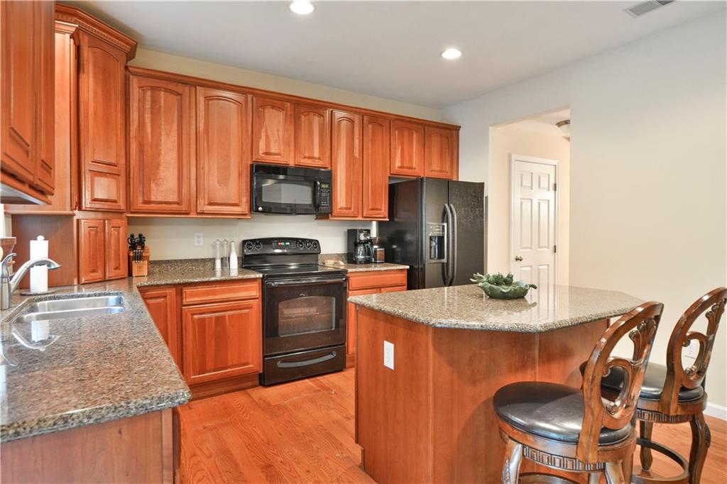 132 Walnut Drive McKees Rocks, PA 15136 - Photo 5 of 25 The fully-equipped kitchen boasts cherry cabinetry and granite counters! The island has room for two stools. Recessed lighting, cabinet molding and hardwood floors. All appliances are included. The pantry and dining room entry are seen in the back next to the fridge.