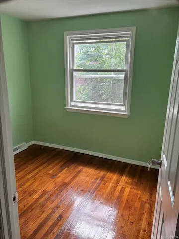 a view of a room with wooden floor and a window