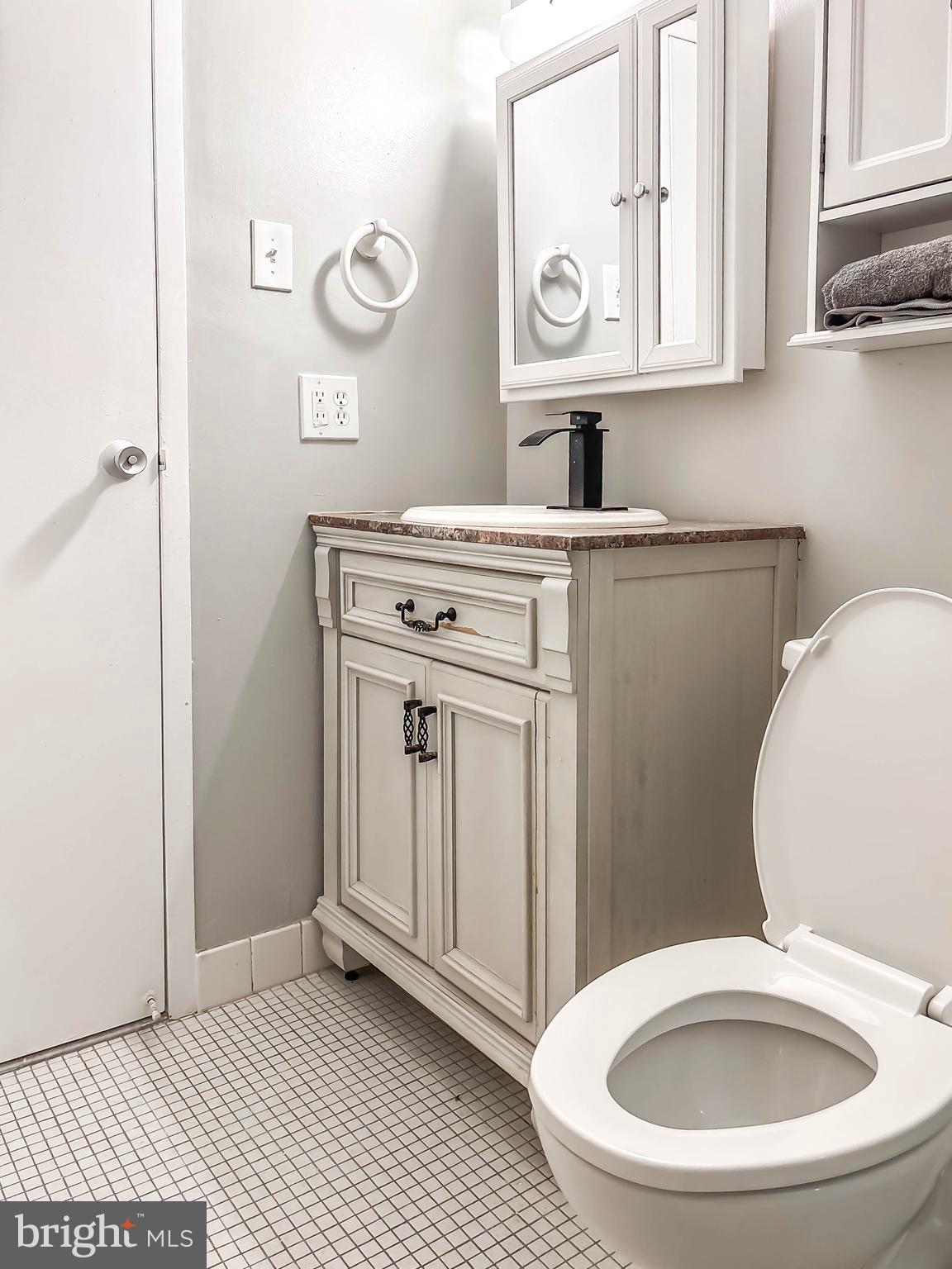 130 Slade Avenue, Unit 414 Baltimore, MD 21208 - Photo 30 of 48 a bathroom with a toilet a sink and mirror