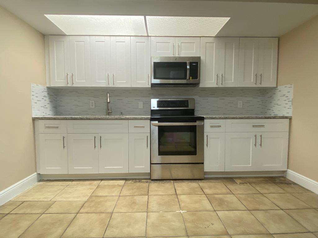 a kitchen with stainless steel appliances granite countertop a stove a microwave and a sink