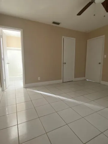 an empty room with a ceiling fan and a window