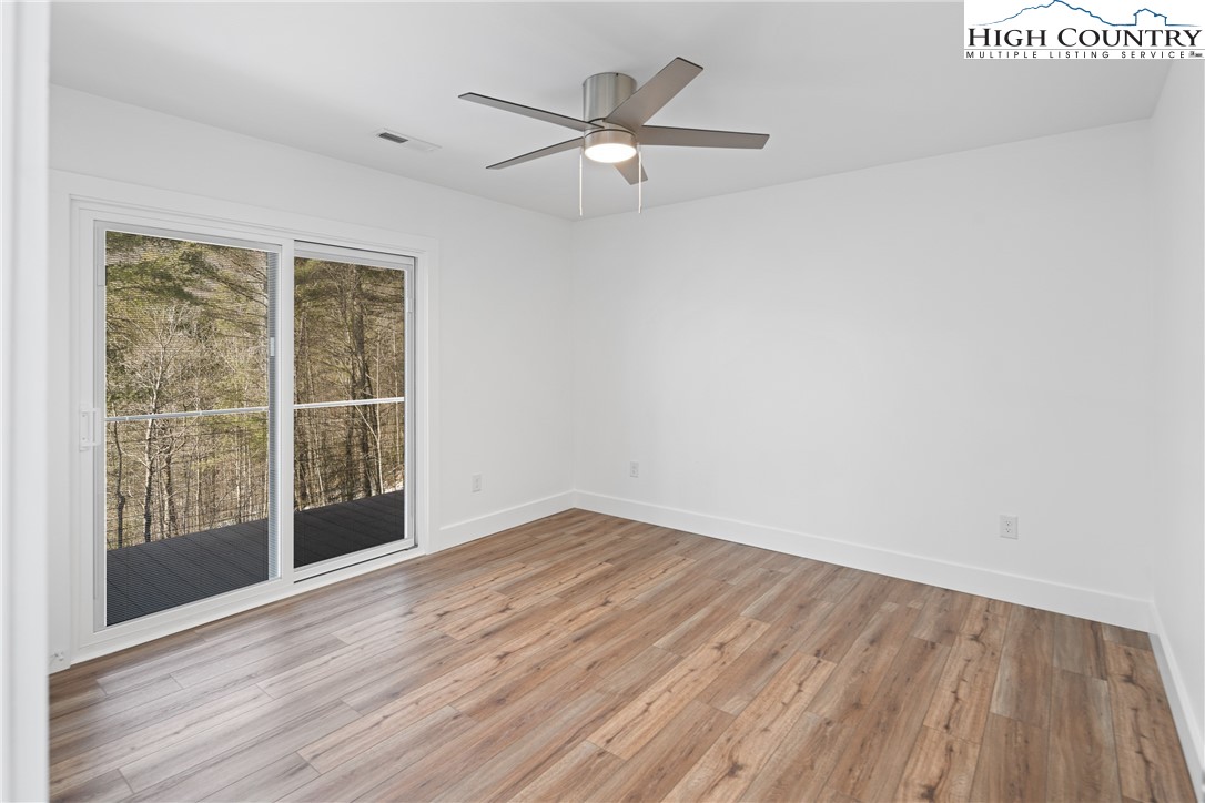 114 Woodpecker Road Purlear, NC 28665 - Photo 16 of 47 wooden floor in an empty room with a window