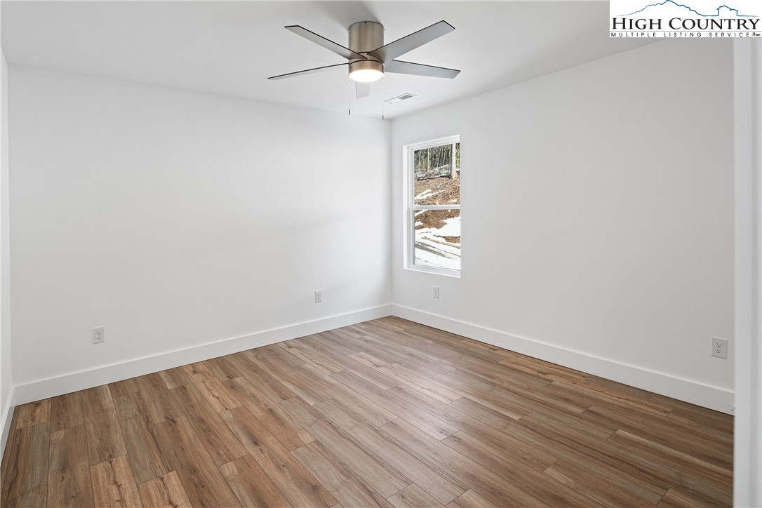 114 Woodpecker Road Purlear, NC 28665 - Photo 20 of 47 wooden floor in an empty room with a window
