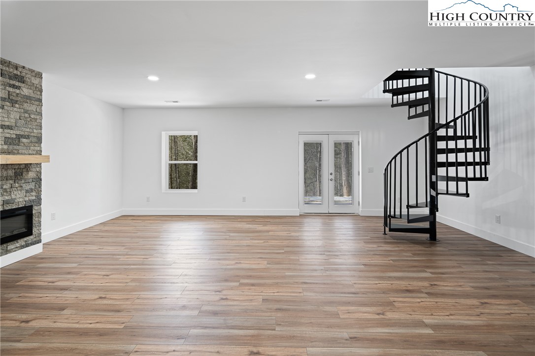 114 Woodpecker Road Purlear, NC 28665 - Photo 21 of 47 a view of a room with wooden floor staircase and a ceiling fan