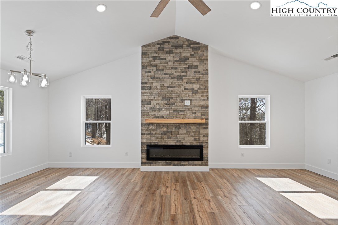 114 Woodpecker Road Purlear, NC 28665 - Photo 9 of 47 a view of an empty room with a window and wooden floor