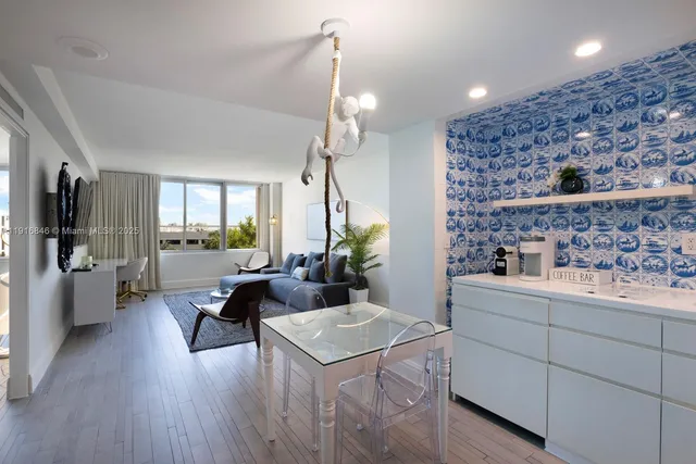 a living room with furniture a chandelier and a dining table with wooden floor