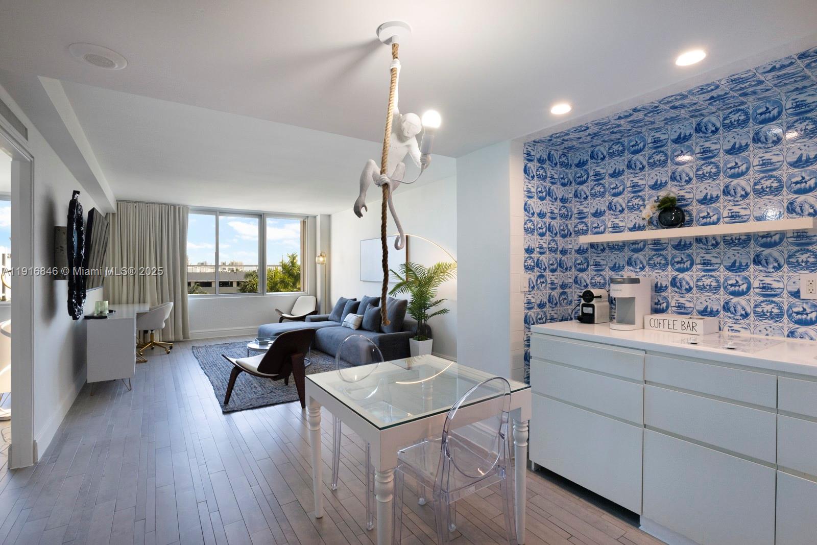 a living room with furniture a chandelier and a dining table with wooden floor