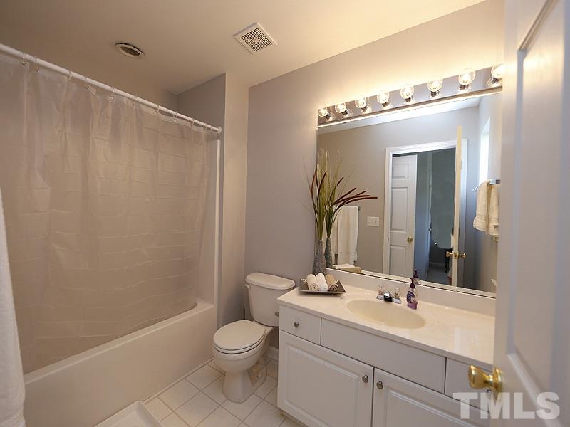 4100 Standing Rock Way Raleigh, NC 27604 - Photo 10 of 11 a bathroom with a toilet a sink a mirror a vanity and shower