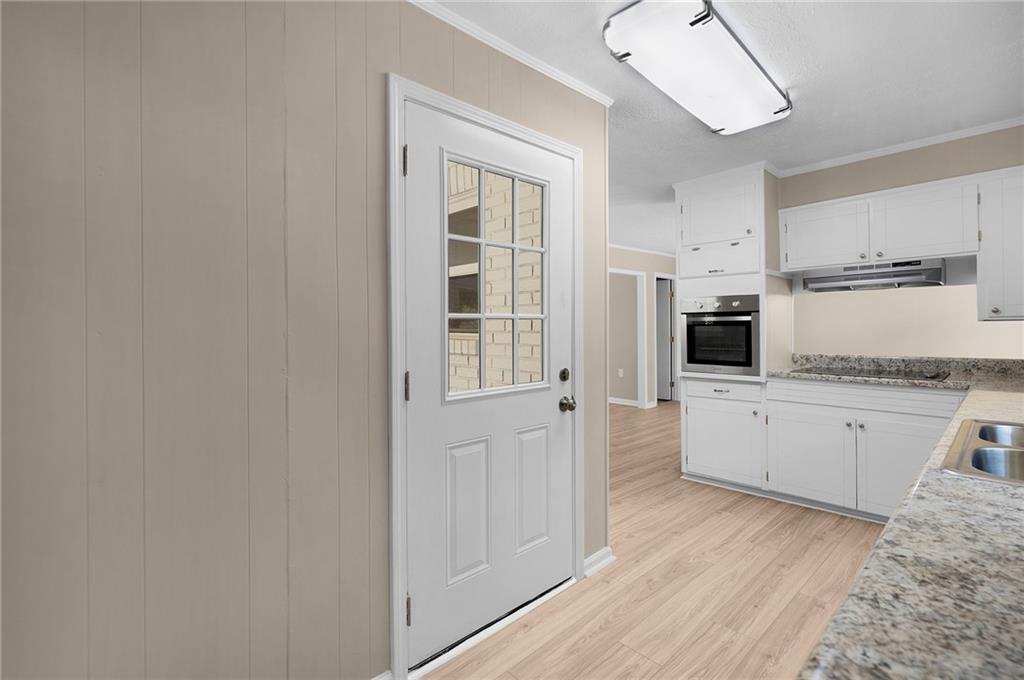 111 Nike Drive Calhoun, GA 30701 - Photo 16 of 36 a kitchen with granite countertop a refrigerator a stove a sink and white cabinets with wooden floor