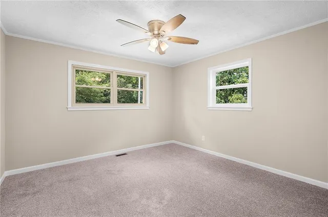 an empty room with a window and a fan