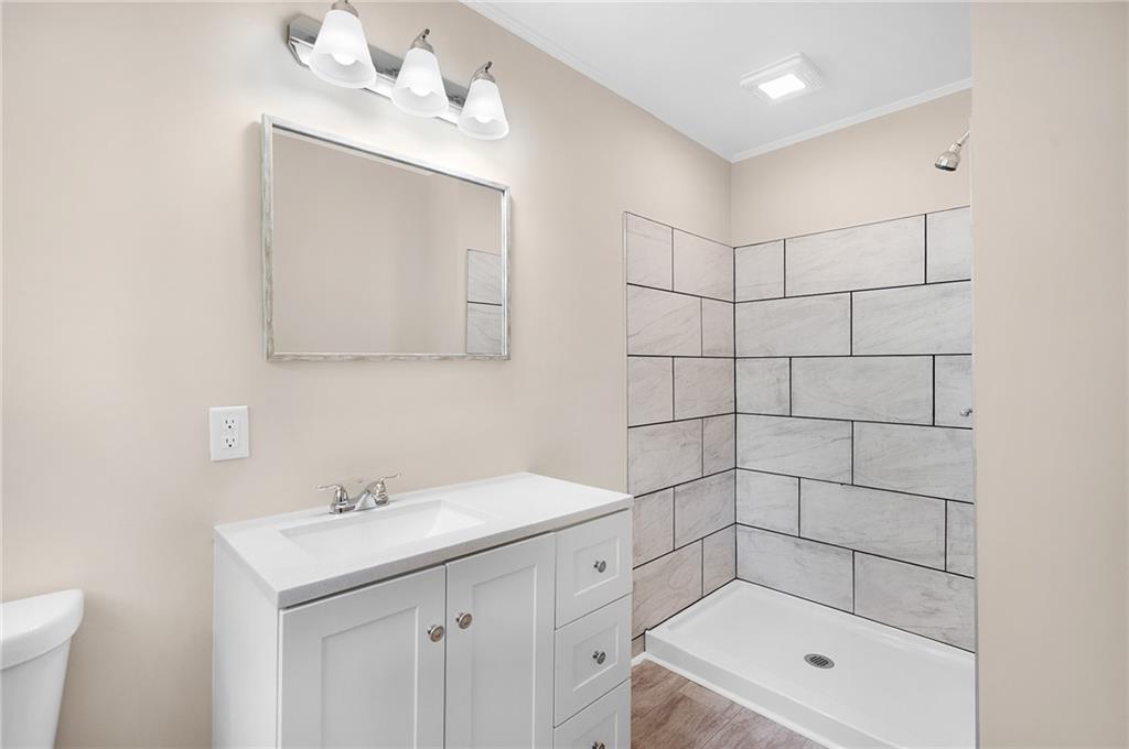 111 Nike Drive Calhoun, GA 30701 - Photo 25 of 36 a bathroom with a shower a sink a toilet and mirror
