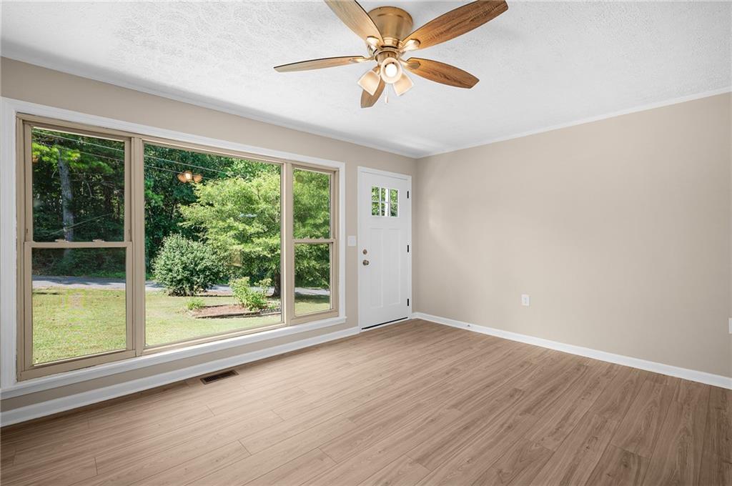 111 Nike Drive Calhoun, GA 30701 - Photo 7 of 36 a view of room with window ceiling fan and hardwood floor