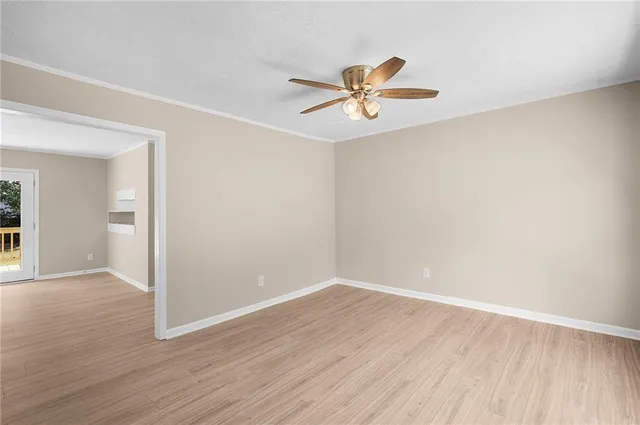 a view of a room with wooden floor and a ceiling fan
