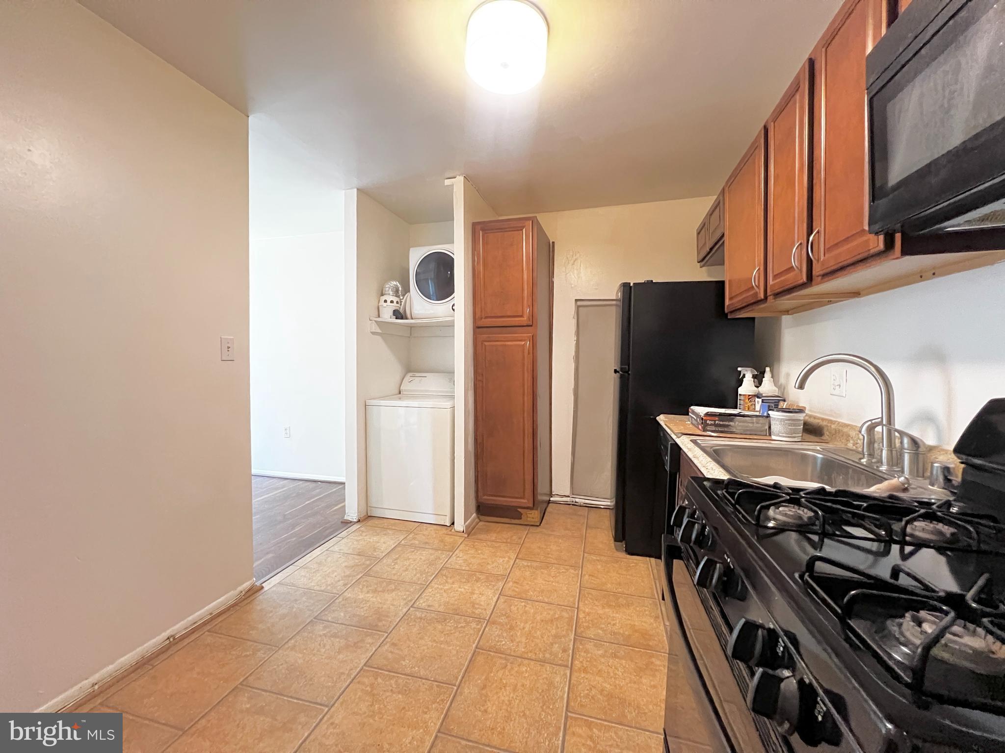 8665 Greenbelt Road, Unit 202 Greenbelt, MD 20770 - Photo 17 of 22 a kitchen with stainless steel appliances a stove a sink and a refrigerator