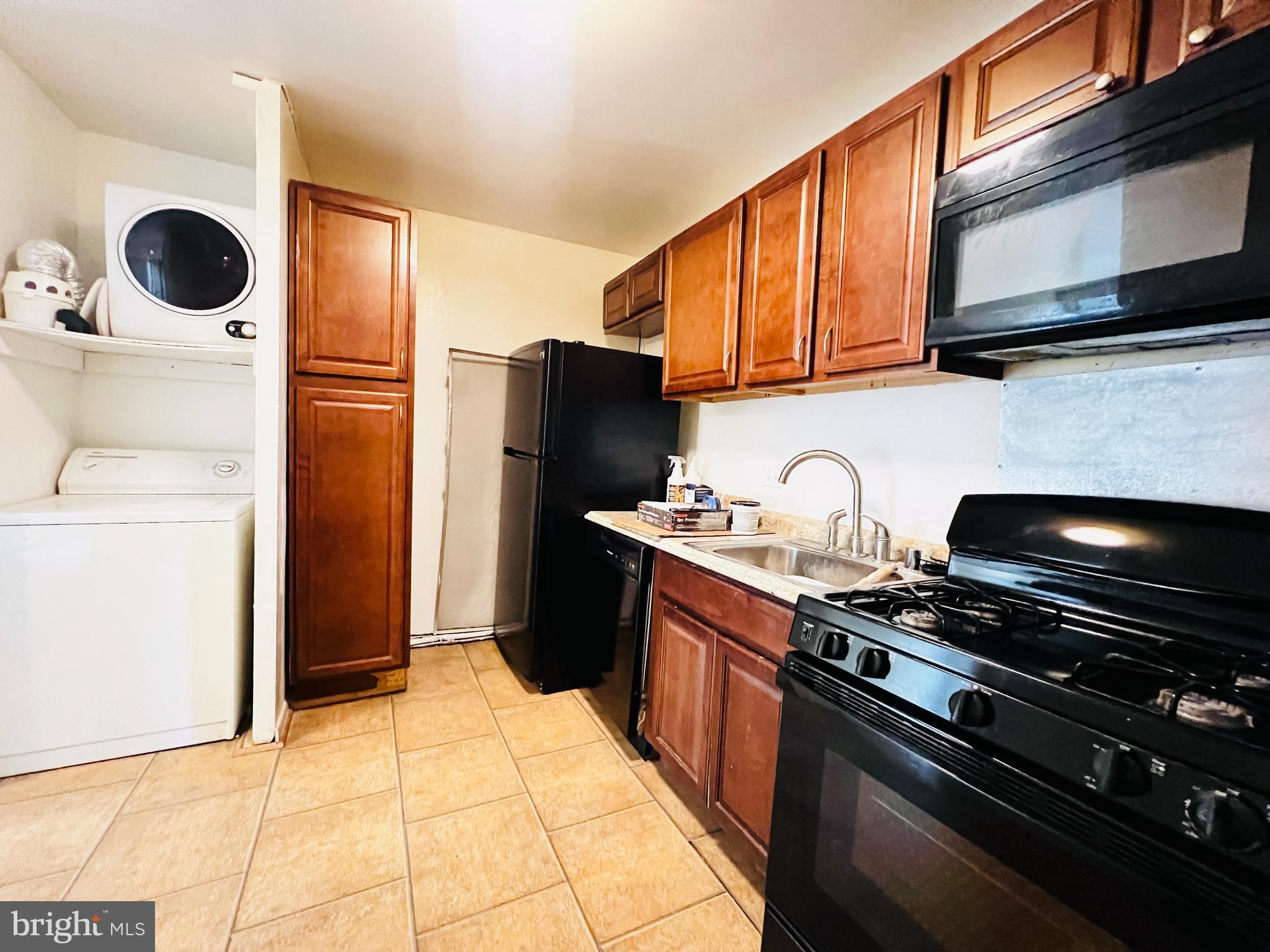 8665 Greenbelt Road, Unit 202 Greenbelt, MD 20770 - Photo 21 of 22 a kitchen with stainless steel appliances granite countertop a refrigerator a stove and a sink