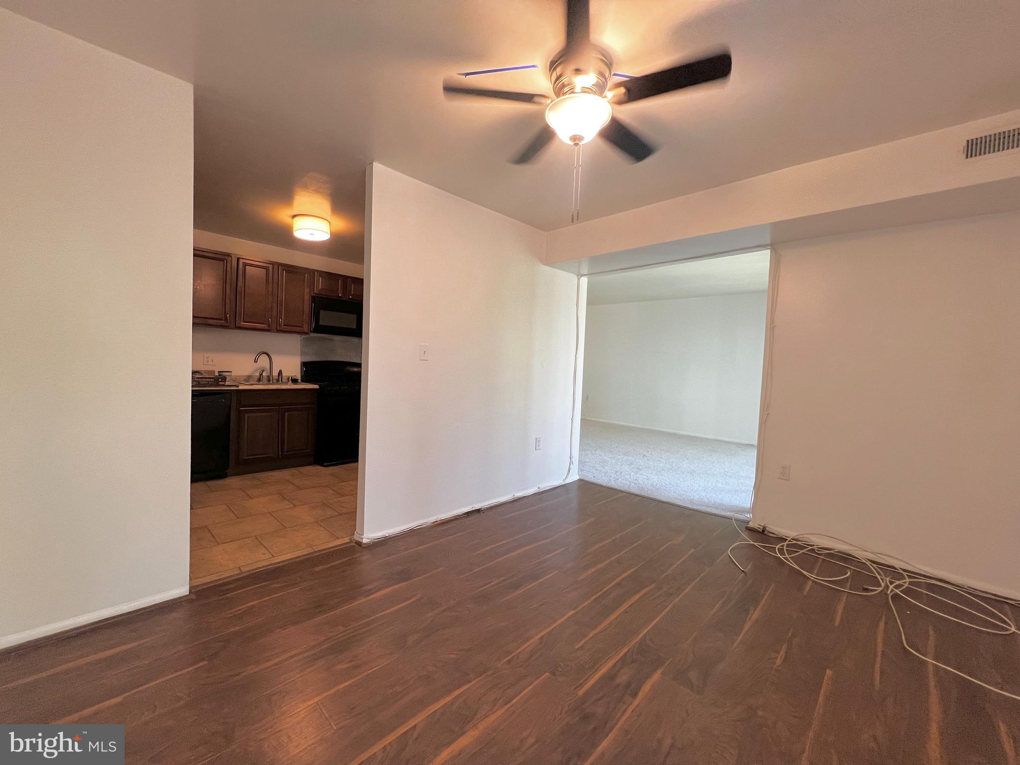 8665 Greenbelt Road, Unit 202 Greenbelt, MD 20770 - Photo 10 of 22 wooden floor in an empty room with a kitchen