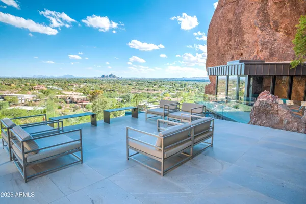 a view of a patio with a table chairs and a small yard