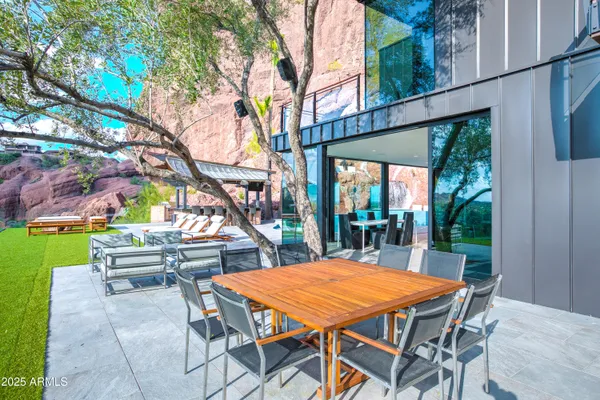 a dining hall with stainless steel appliances kitchen island granite countertop a table and chairs