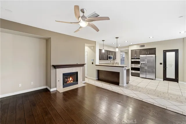 a living room with furniture a fireplace and a ceiling fan