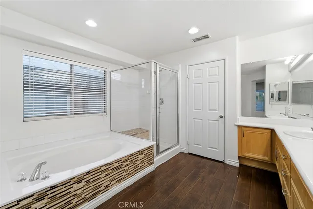 a bathroom with a tub a sink and a mirror
