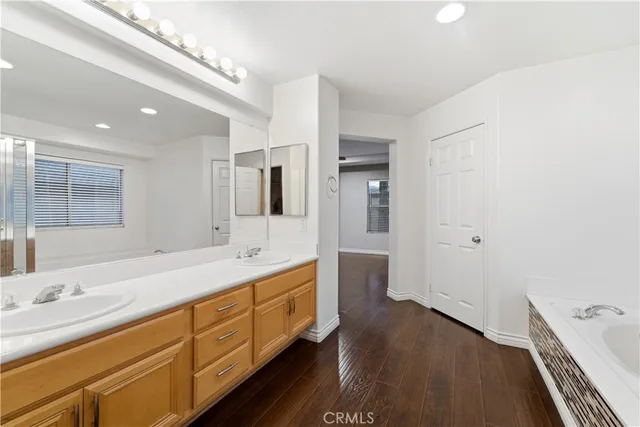a bathroom with a double vanity sink a large mirror and shower