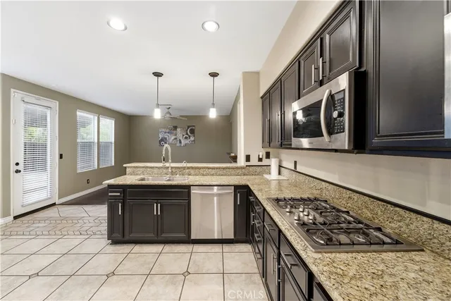 a large kitchen with stainless steel appliances granite countertop a stove and a sink