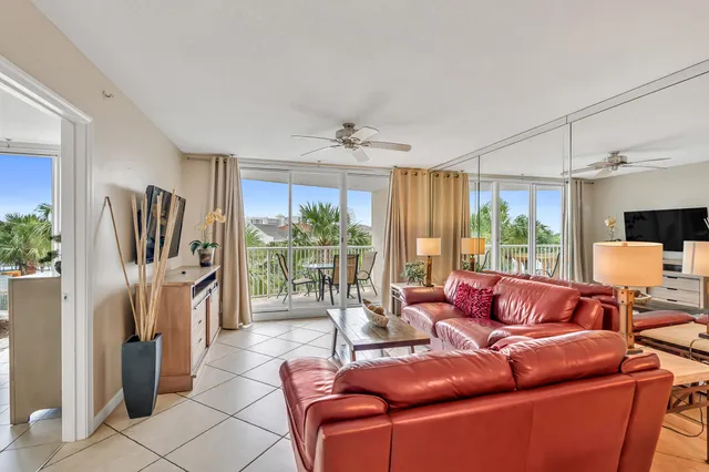a living room with furniture a flat screen tv and a large window