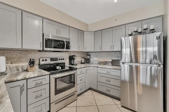 a kitchen with white cabinets stainless steel appliances and a sink