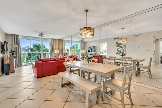 a room with stainless steel appliances kitchen island granite countertop a dining table chairs and a large window