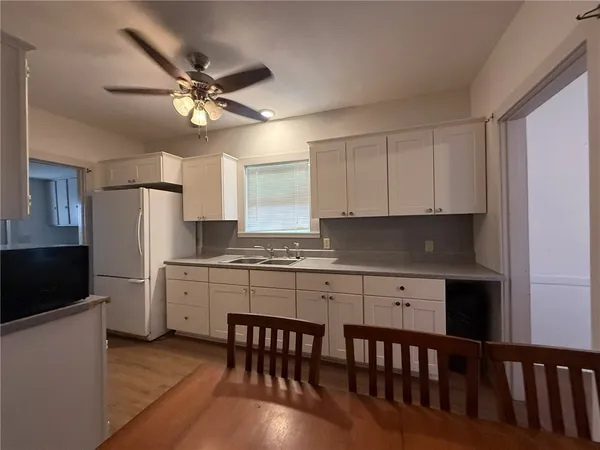 a kitchen with stainless steel appliances white cabinets and wooden floor