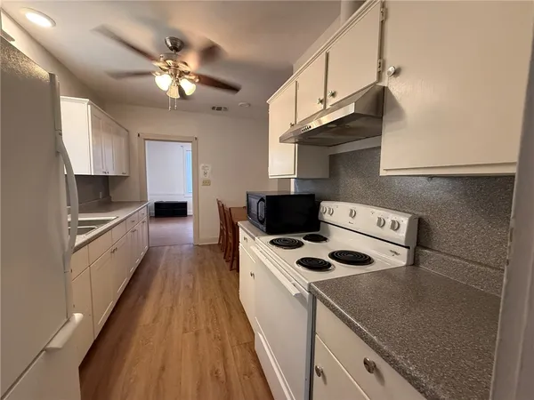 a kitchen with stainless steel appliances granite countertop a sink a stove and a refrigerator