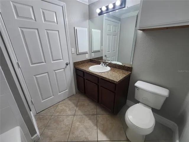 a bathroom with a toilet a sink a vanity and mirror