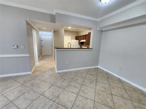 a view of a hallway to room with wooden floor