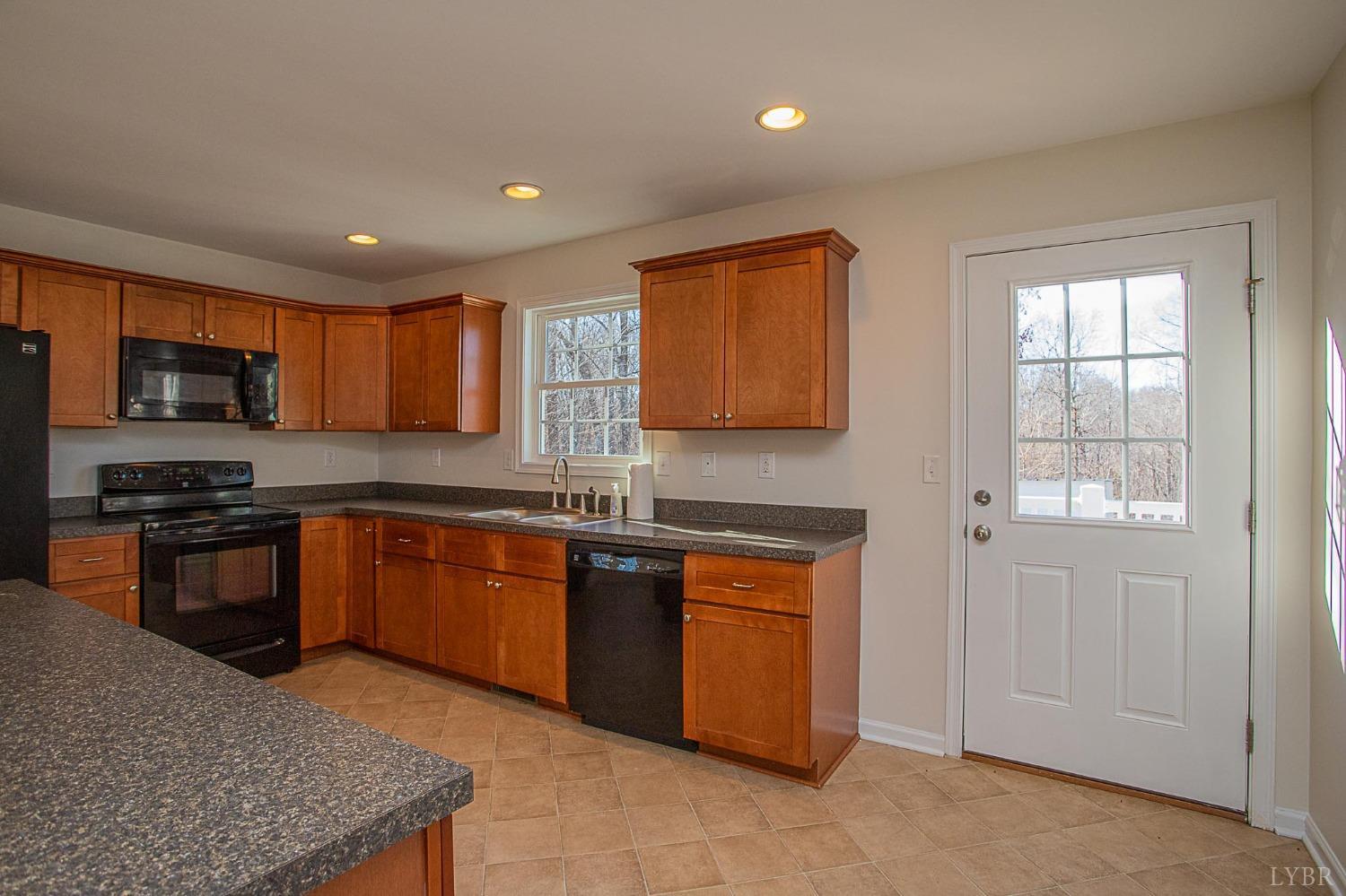 2417 River Road Madison Heights, VA 24572 - Photo 27 of 35 a large kitchen with stainless steel appliances granite countertop a stove a sink dishwasher a microwave oven and a refrigerator with wooden cabinets