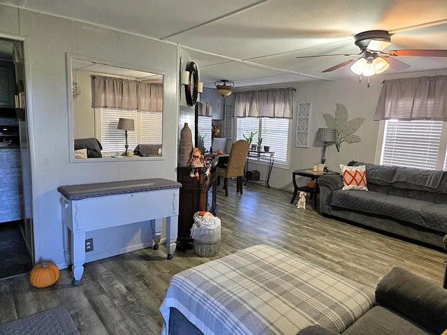 a living room with furniture a large window and a chandelier