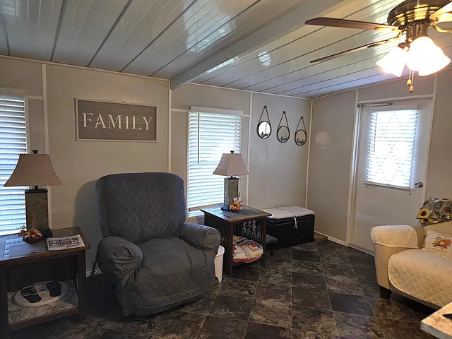 a view of a house with a yard and a large tree