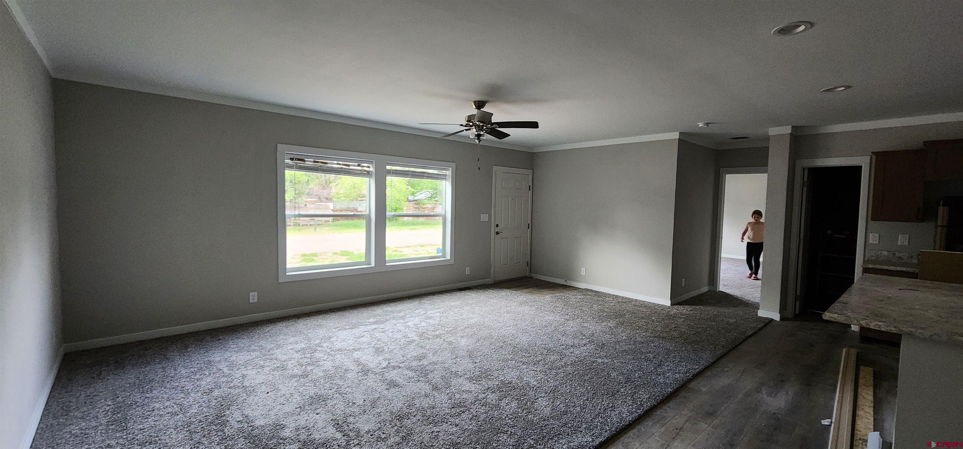 305 9th Street Saguache, CO 81149 - Photo 19 of 32 an empty room with windows and a chandelier fan