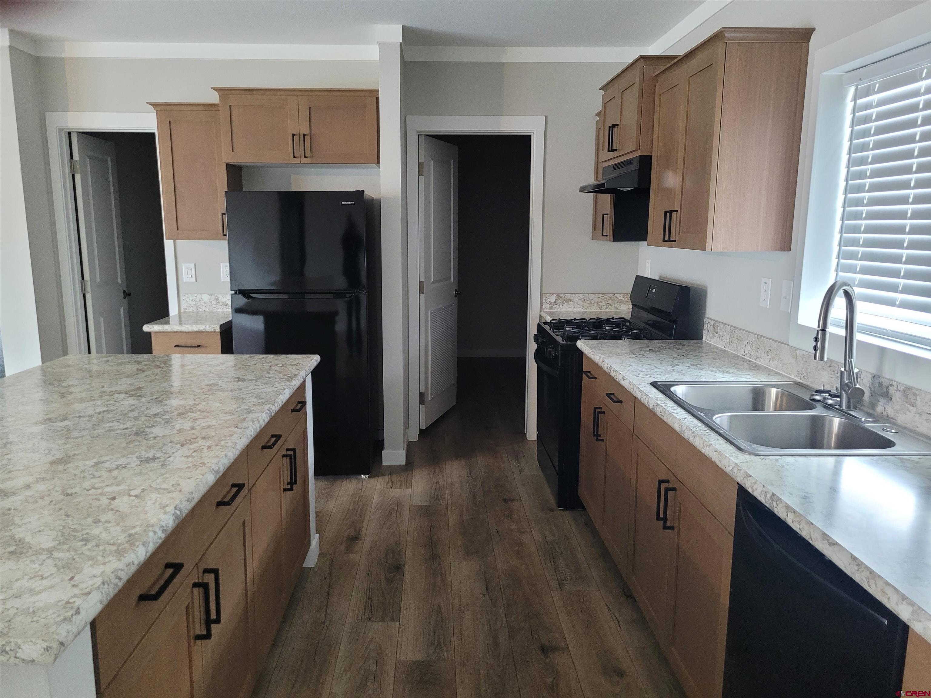 305 9th Street Saguache, CO 81149 - Photo 4 of 32 a kitchen with stainless steel appliances granite countertop a sink stove and refrigerator