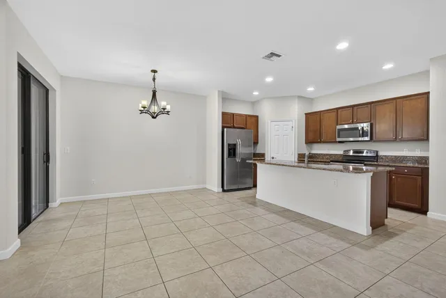 a kitchen with stainless steel appliances granite countertop a refrigerator and a stove top oven