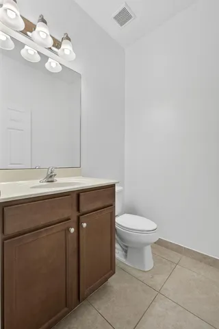 a bathroom with a sink vanity and a toilet